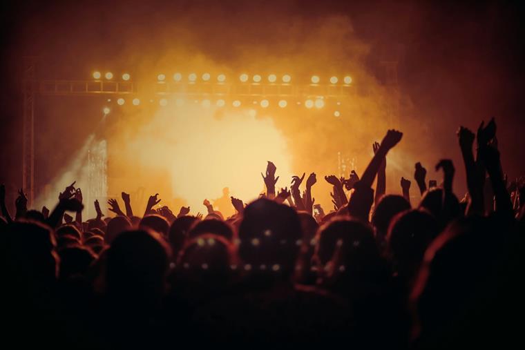 A night out with your favorite comedians: a packed crowd under amber stage lights through haze