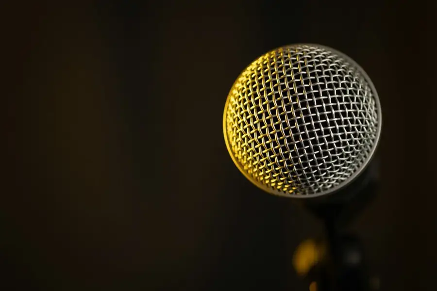 A gold microphone in warm light, for a comic’s free podcast listing on D.O.C.