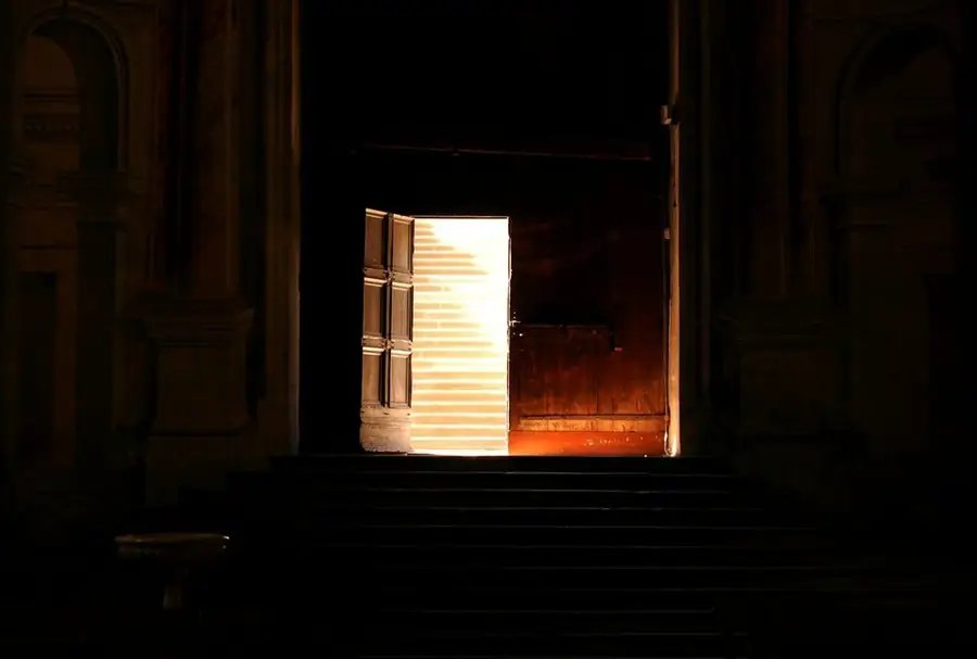 A door standing open onto warm light in a dark stone building: bouncing back after bombing