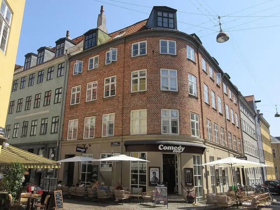 Comedy Zoo on the corner of Knabrostræde and Kompagnistræde, Copenhagen, its sign over the door and café tables outside