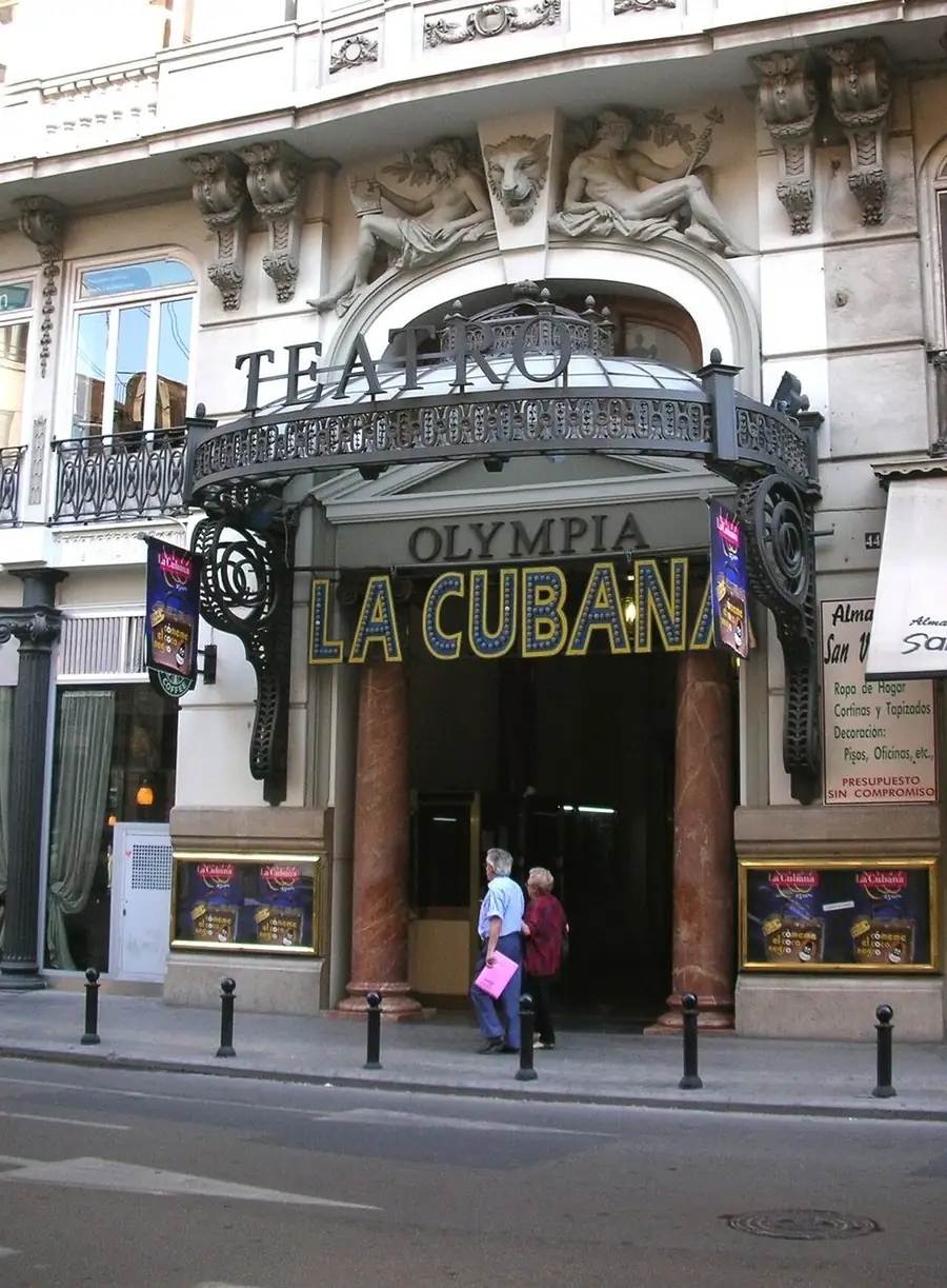 The entrance of the Teatro Olympia in Valencia, its name over the canopy and posters by the doors