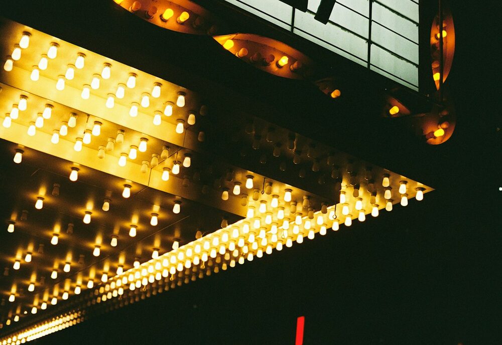 Where comedian tour dates go up in lights: the underside of a theatre marquee studded with warm bulbs
