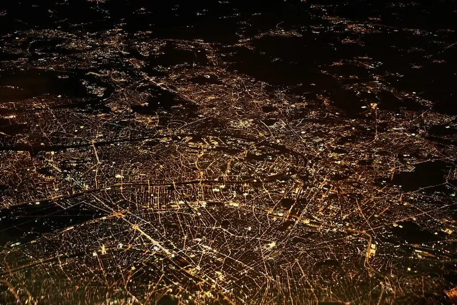 A city's street grid at night, seen from the air: the comedy club circuit