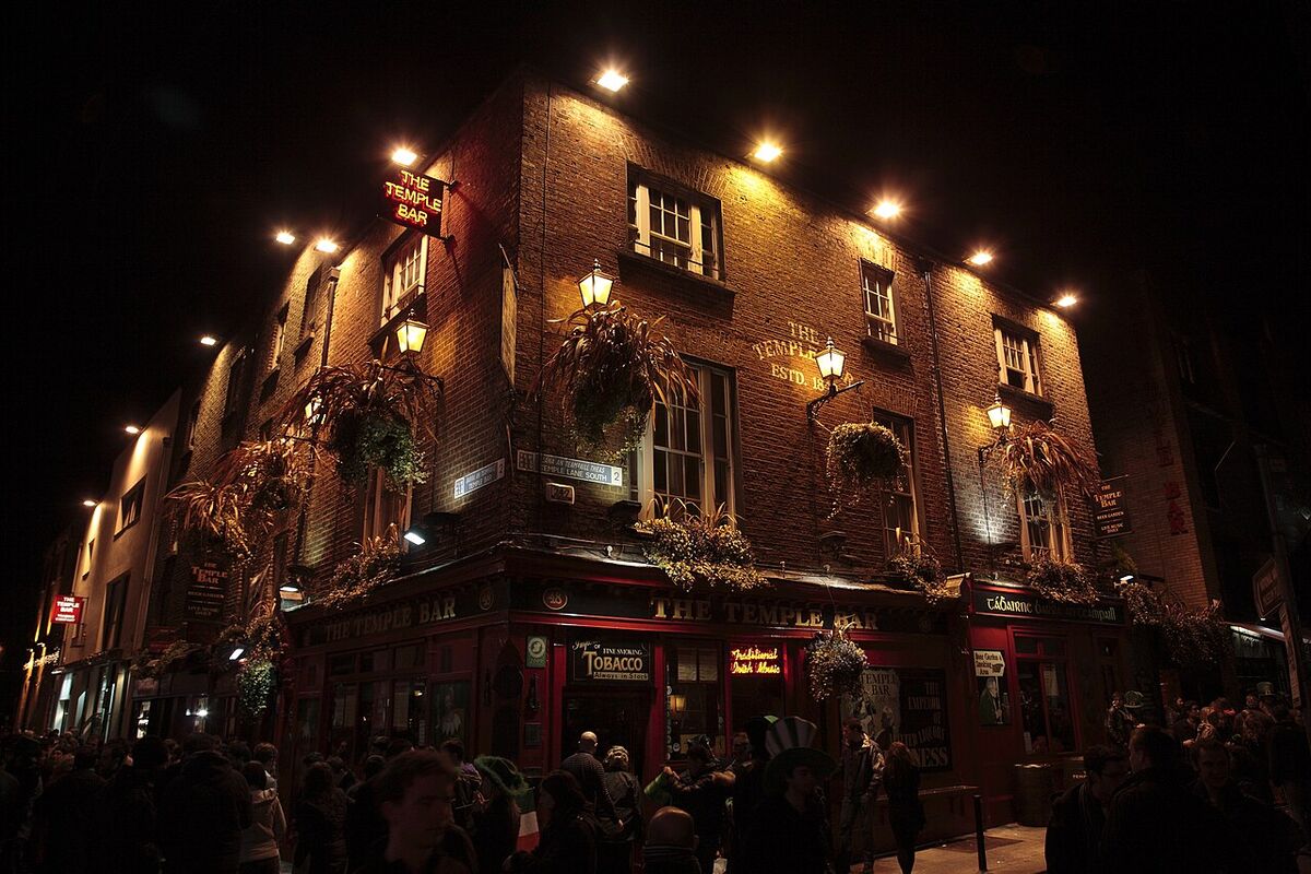 Stand-up comedy in Ireland: The Temple Bar pub in Dublin at night, its red front and hanging baskets lit and the street busy below