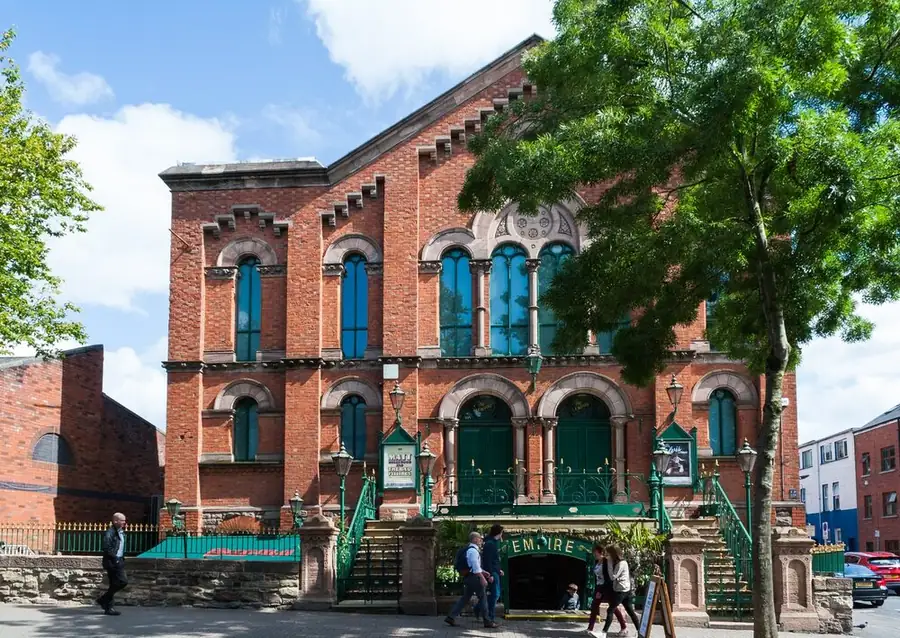 The Belfast Empire on Botanic Avenue: a red brick former church with a green 'Empire' sign over the entrance.